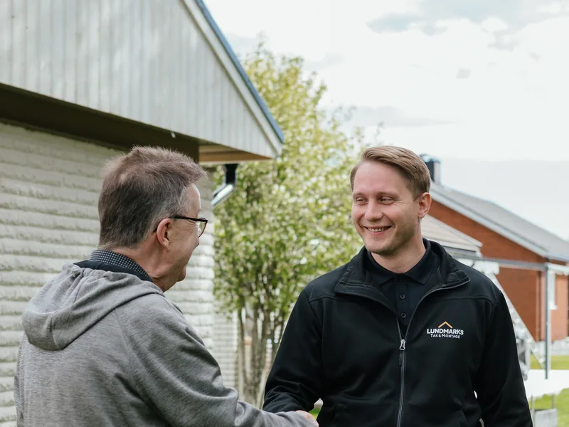 Medarbetare från Lundmarks hälsar på en kund vid ett hembesök